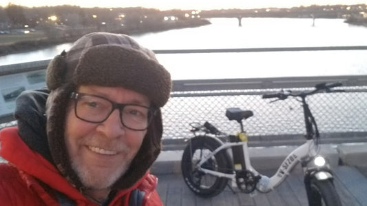 Man with White E-Bike in Front of River