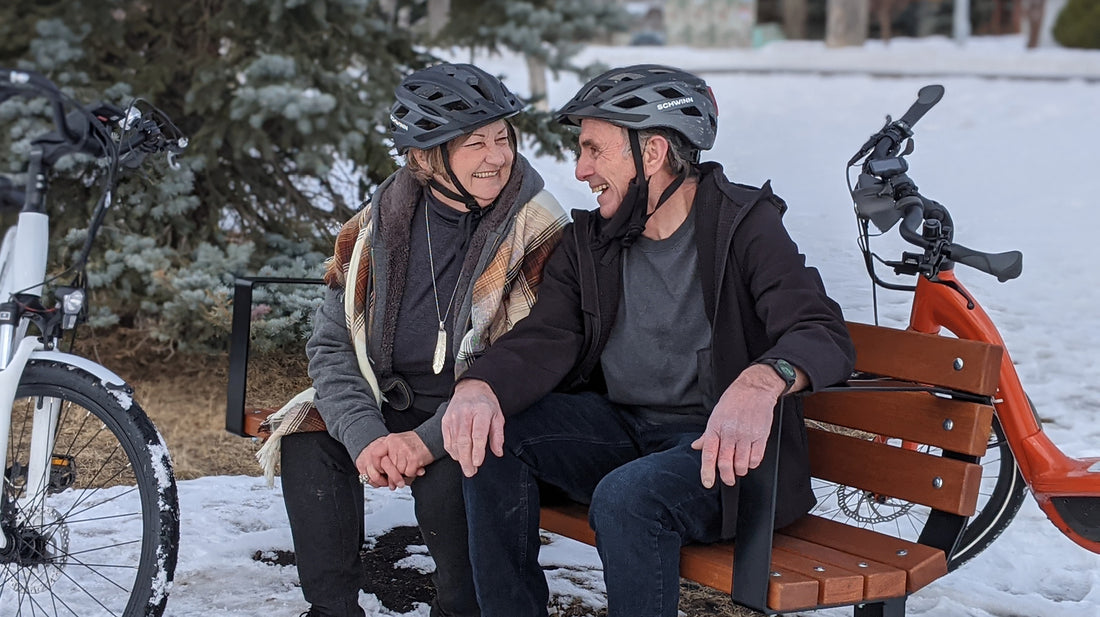 A Couple Sitting on Bench with E-Bikes